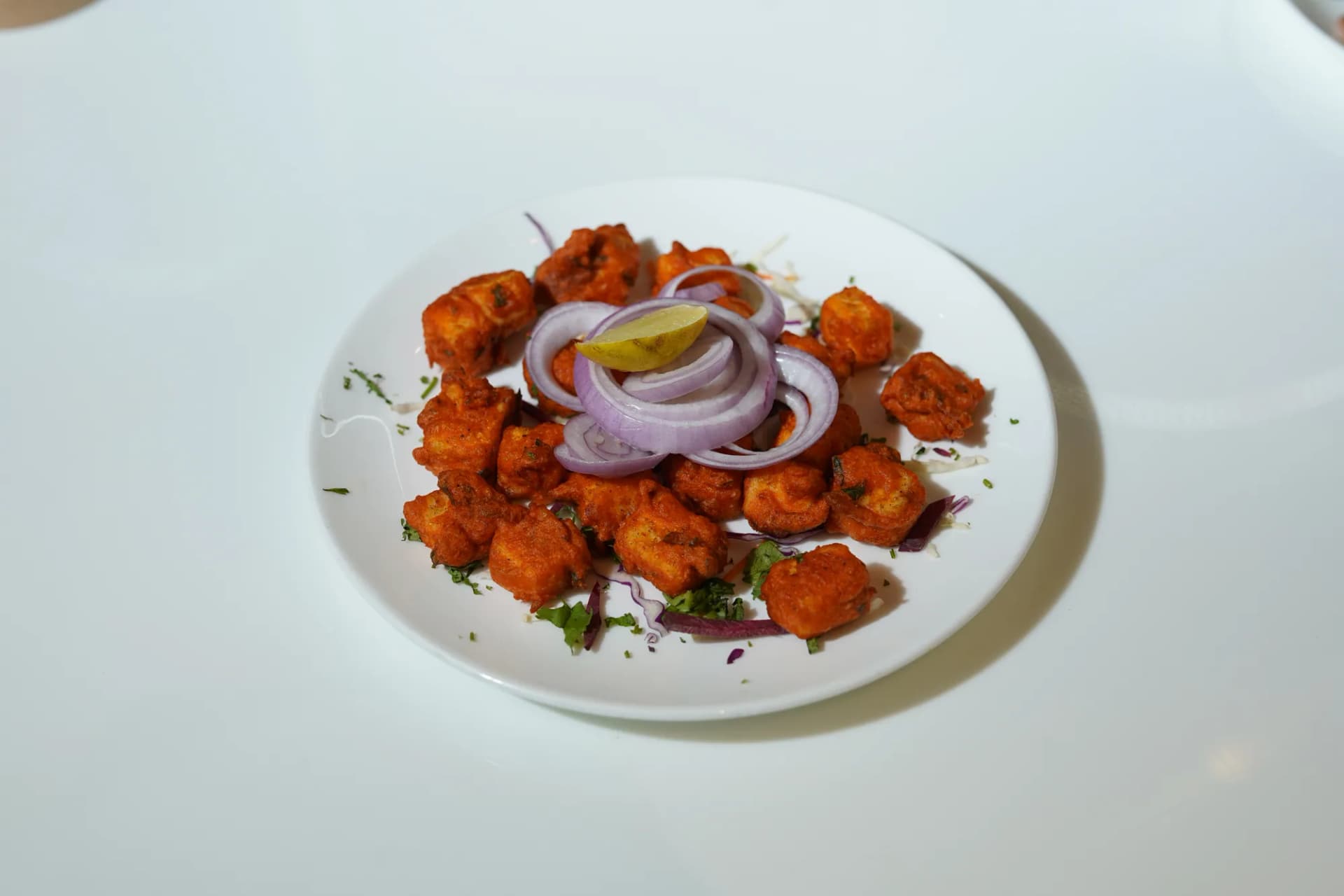 Crisp spiced chicken bites finished with onion and lemon